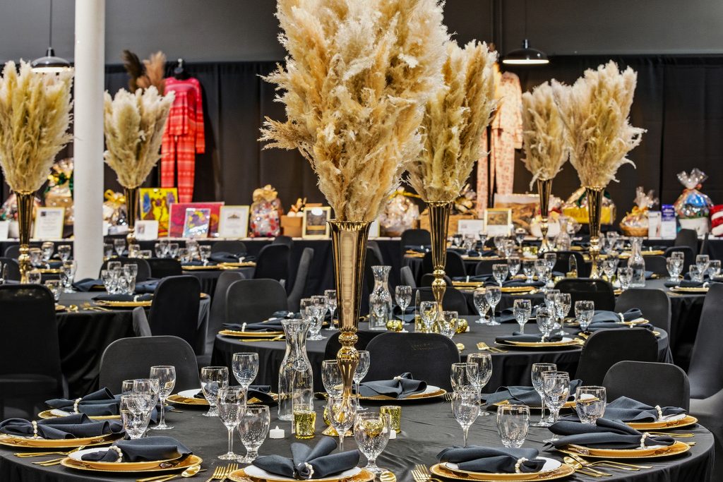 Close-up of elegant dining table setup with glassware and gold cutlery