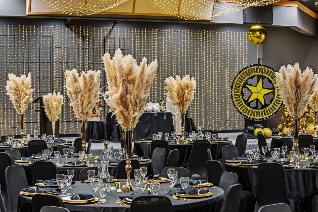 Event venue with stage presentation screen and luxury table arrangements