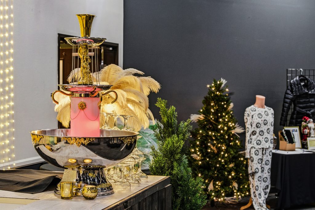 Champagne fountain setup with gold décor, feather lamp, and festive lighting arrangement