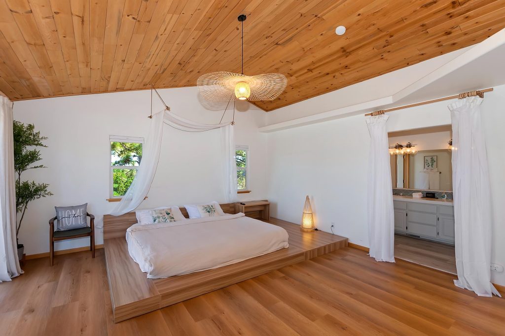 Spacious mountain cabin bedroom with wood ceiling, platform bed, and bright modern rustic interior design