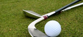 Close-up of golf clubs and a ball on the grass at Big Bear golf course.