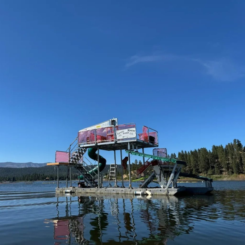 Captain John's marina floating water attraction on Big Bear Lake with mountains in background