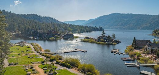 Aerial view of Boulder Bay Park in Big Bear featuring landscaped walking paths, docks, granite boulders, and scenic lake and mountain views.