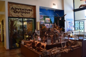 A cozy and rustic bedroom in a Big Bear home with a bed, wooden furniture, and a window with a view of the outdoors.