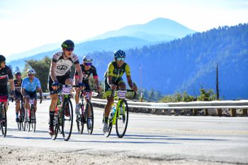 Tour de Big Bear cyclists riding along a scenic mountain road in Big Bear Lake, CA