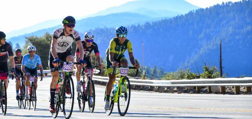 Tour de Big Bear cyclists riding along a scenic mountain road in Big Bear Lake, CA