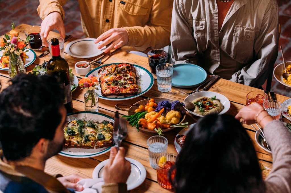A group of people enjoying a meal together at a table in DeLaNonna Restaurant, Big Bear.
