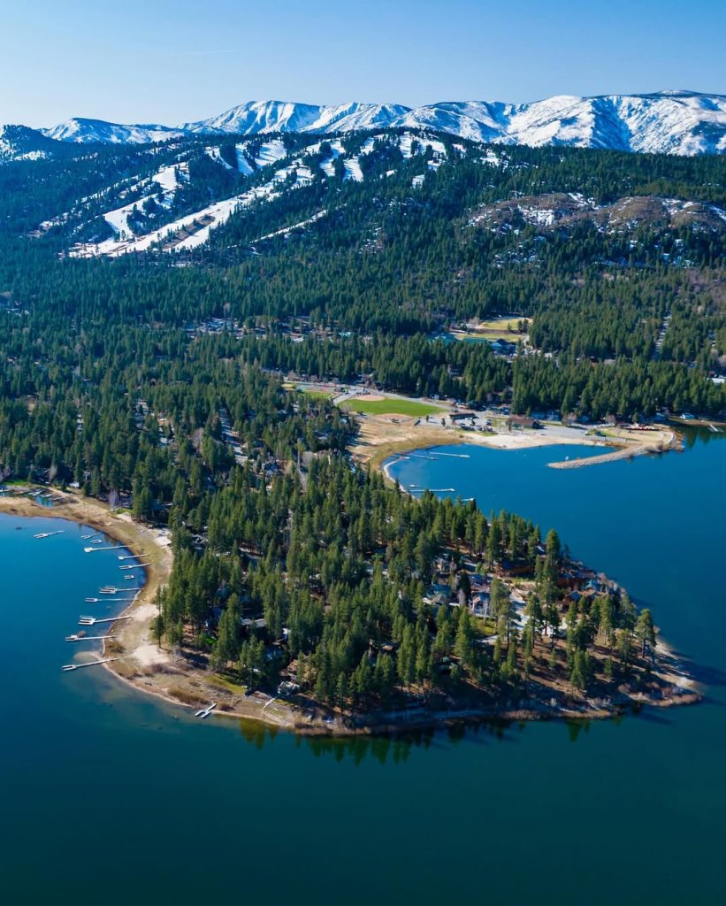 Aerial view of Eagle Point area in Big Bear, showing forested land, lakeshore, and surrounding mountains.