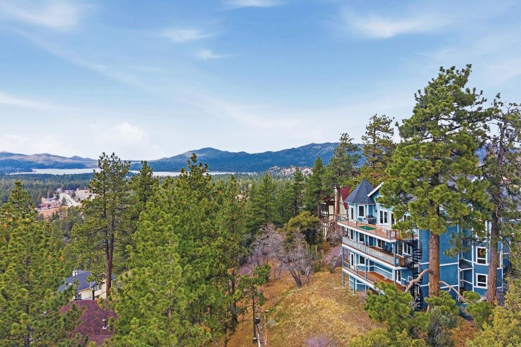 Aerial view of Edgar’s Hideaway cabin surrounded by pine trees with mountain and lake views in Big Bear.