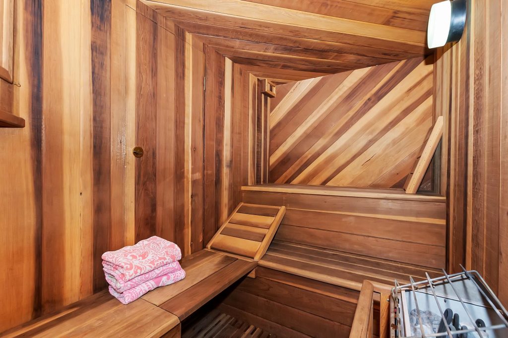 Private cedar wood sauna room at Edgewood Mansion with bench seating and warm rustic design.