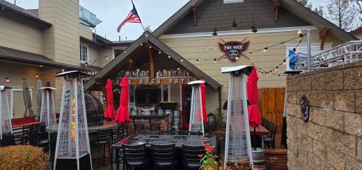 Outdoor patio area at Fire Rock Burgers & Brews with seating, heaters, and restaurant signage