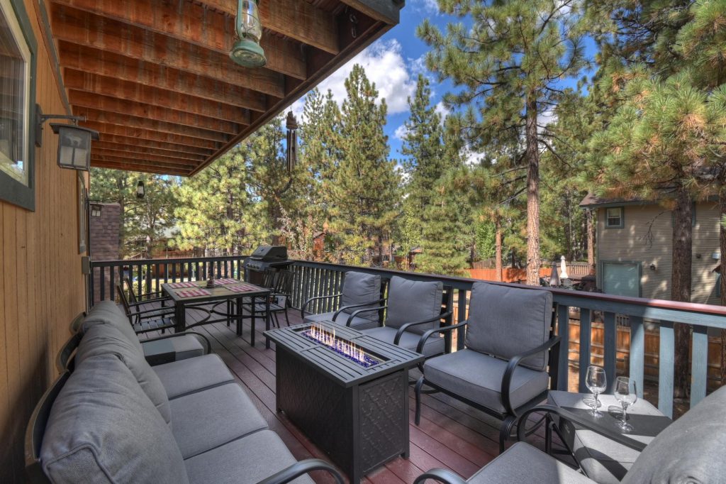 Forest Hollow Big Bear vacation rental patio seating area with fire table and forest views