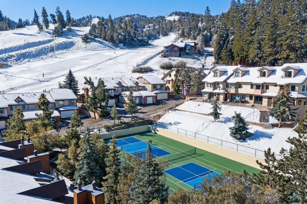 Snow-covered Big Bear resort homes with tennis courts and mountain landscape views