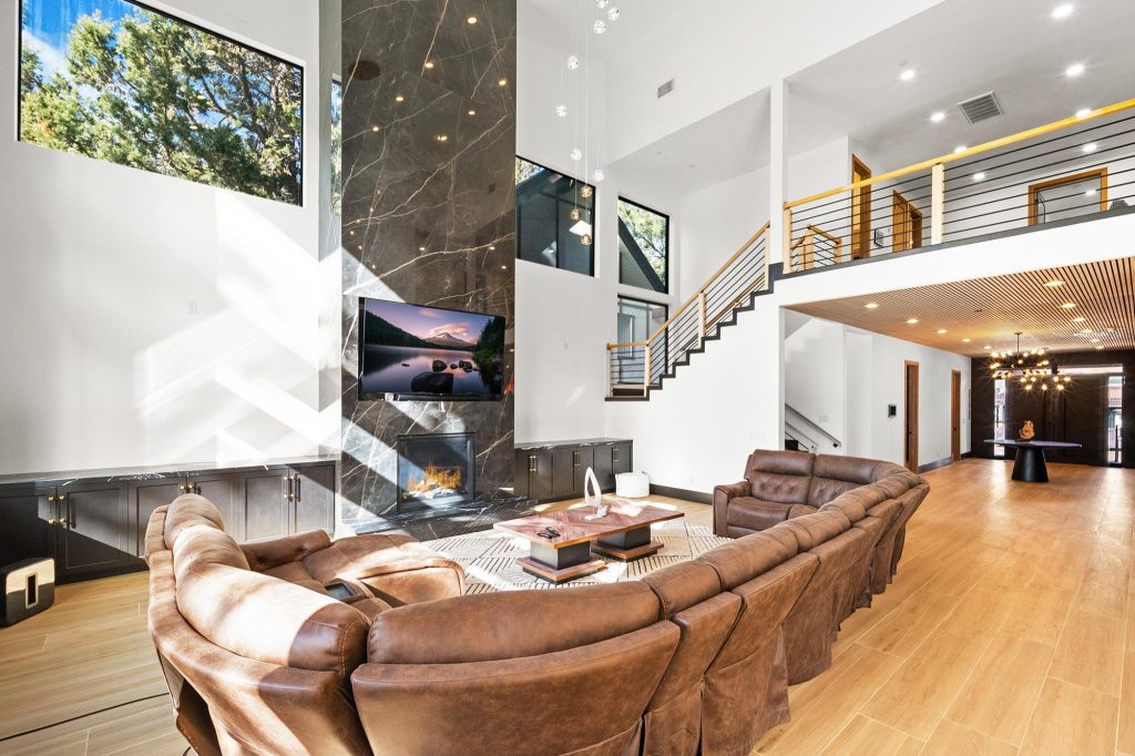 Modern open-concept living room at The Getaway Club with fireplace, high ceilings, and comfortable seating.