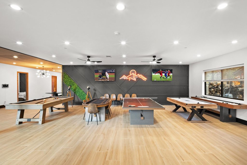 Spacious game room at The Getaway Club featuring pool tables, ping pong, shuffleboard, and entertainment area.