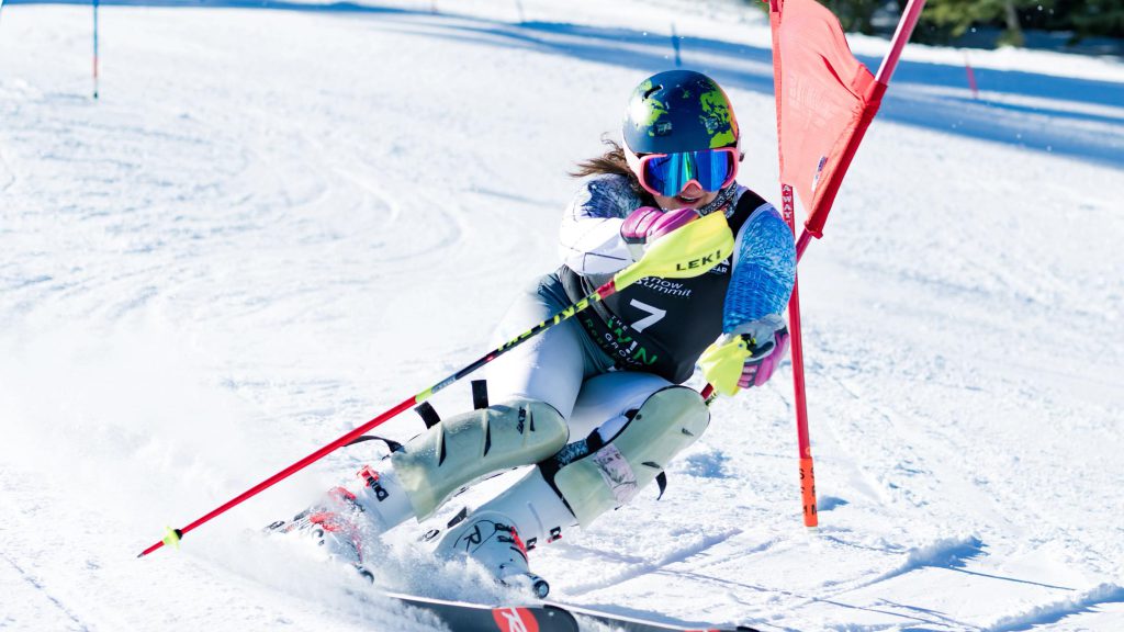 A snowboarder is actively snowboarding down a snowy slope at Big Bear