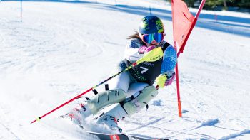 A snowboarder is actively snowboarding down a snowy slope at Big Bear