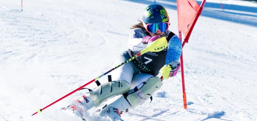 A snowboarder is actively snowboarding down a snowy slope at Big Bear