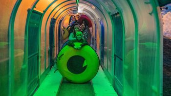Visitors enjoying glow tubing tunnel at Big Bear Snow Play