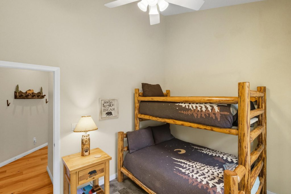 The Hidden Estate in Big Bear by Destination Big Bear bunk bed bedroom with grey comforters and nightstand with lamp
