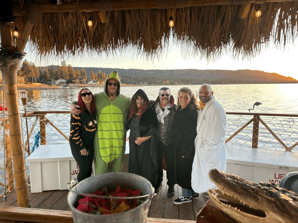 Friends in Halloween costumes enjoying a lakeside Hula-ween Luau in Big Bear
