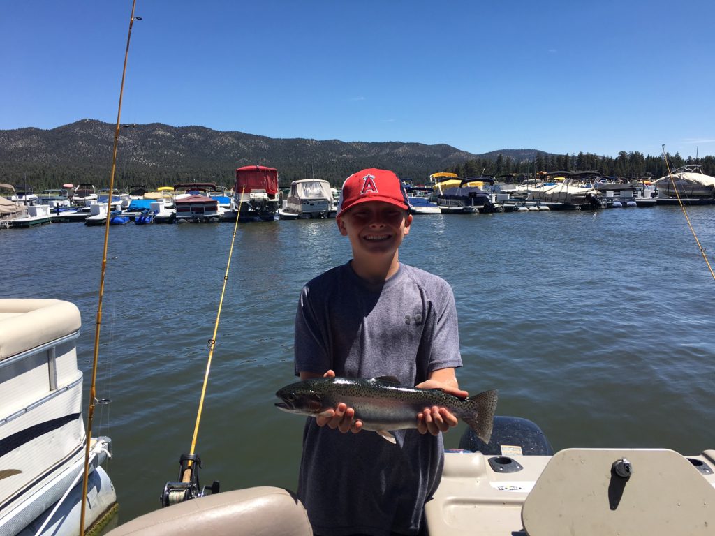 Kid holding a trout after fishing trip at Big Bear Lake with Cantrell Guide Service