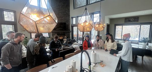 A group of people standing in a kitchen during the Kim Lansell production shoot in Big Bear.