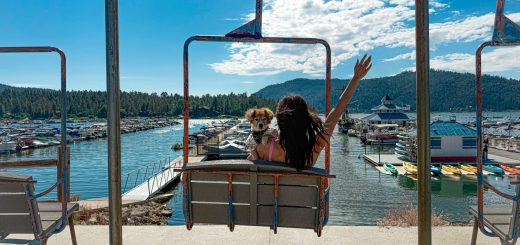 Scenic Big Bear Lake view with marina, mountains, blue sky, and chairlift ride