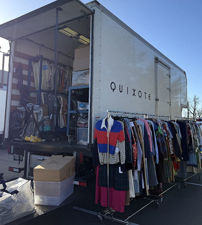 A truck loaded with costumes from Kim Lansell Production Costumes in Big Bear, showcasing various clothing items.