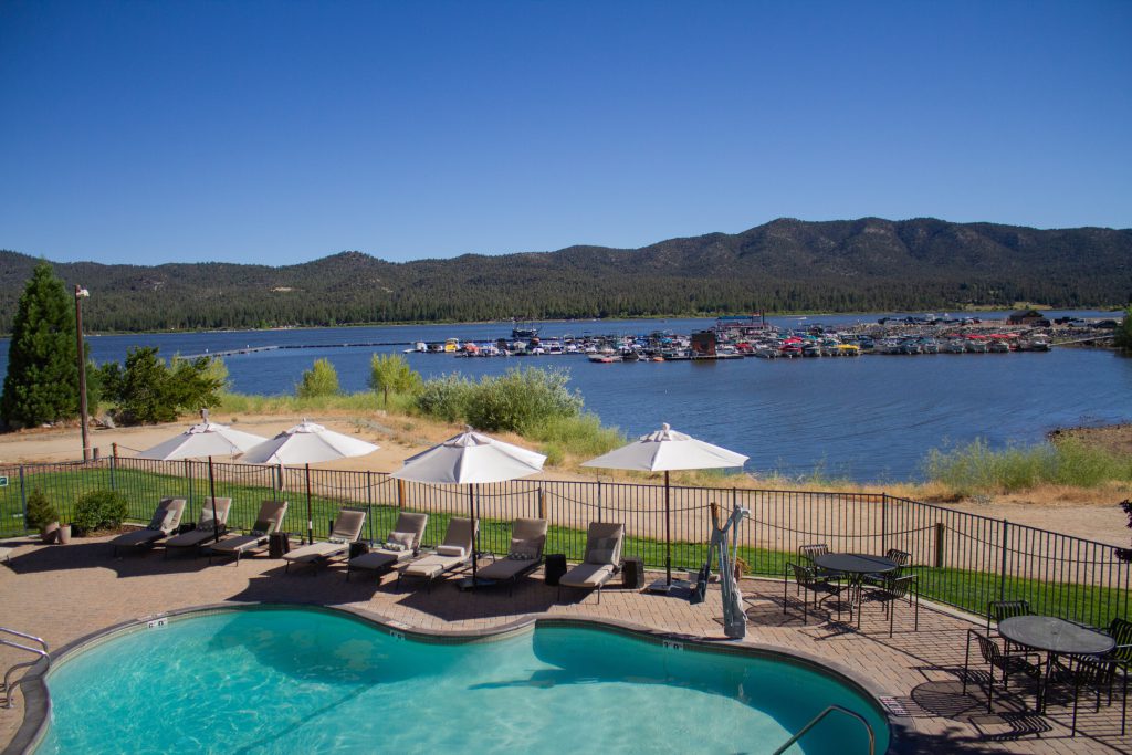 Lakefront pool with lounge chairs and umbrellas at Big Bear.
