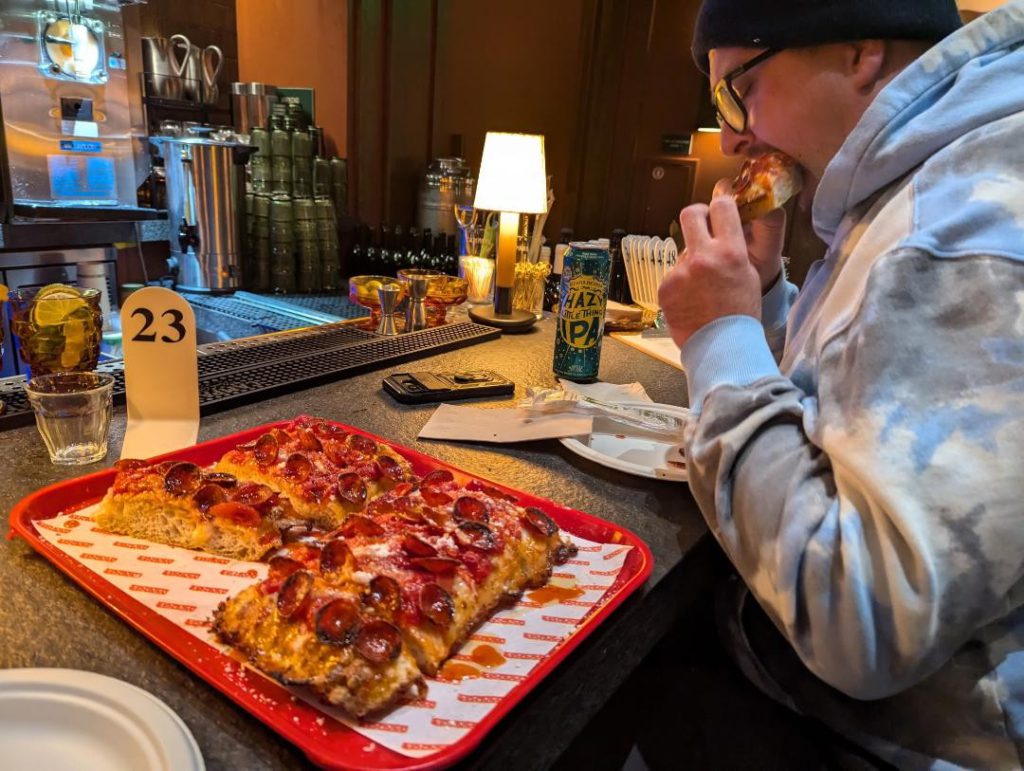 Delicious Detroit-style pepperoni pizza with craft IPA beer served at a Big Bear bar.