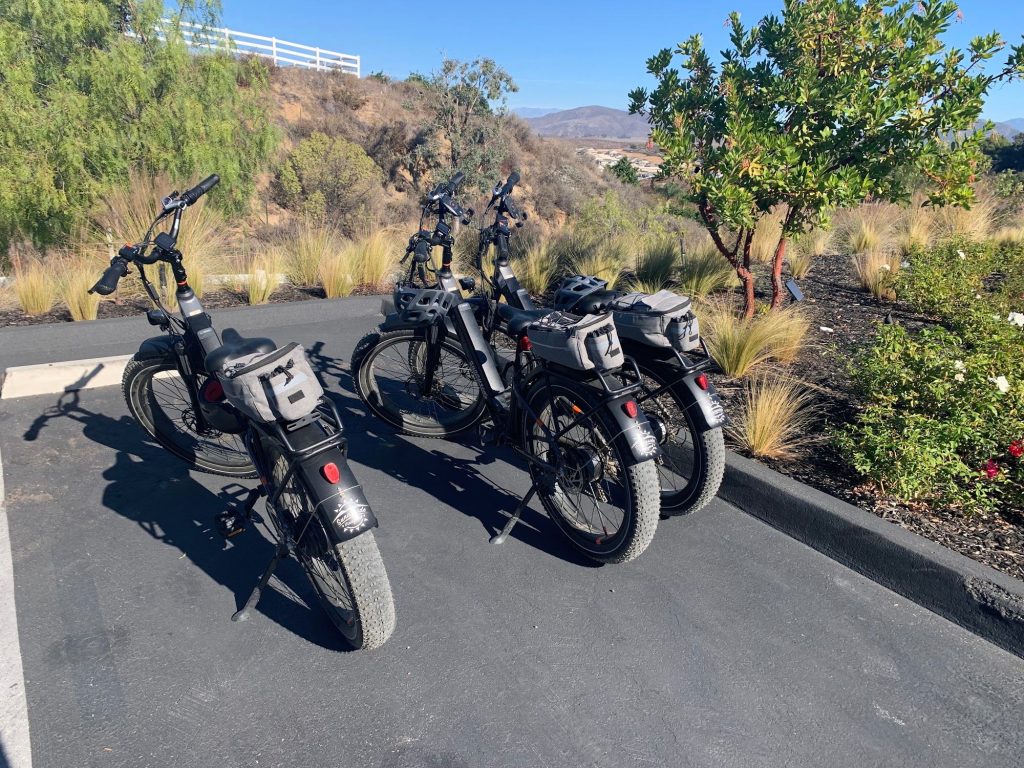 Multiple electric bikes parked outdoors with scenic mountain views and natural surroundings