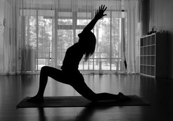 A woman practicing yoga in a serene room at Mountain Yoga Center in Big Bear.