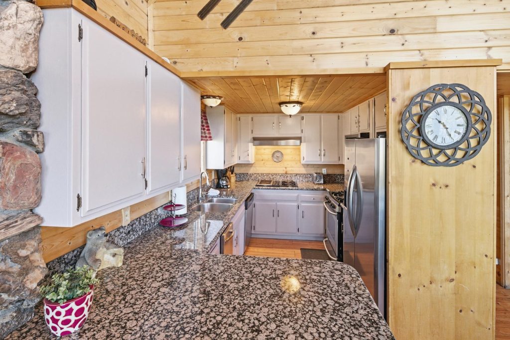 Nature's Dream cabin kitchen with granite countertops and white cabinets