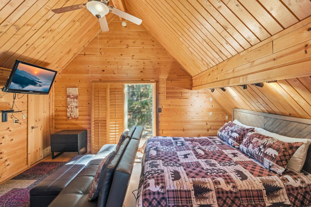 Nature's Dream loft bedroom with rustic wood interior and seating area