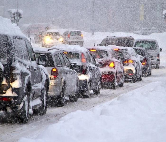 Several cars are stuck in deep snow on a snowy day at Big Bear Lake, creating a challenging winter scene.