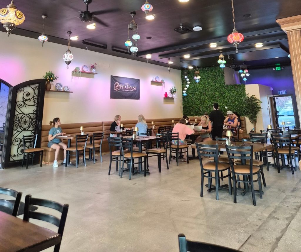 Guests dining inside The Pita House featuring elegant Turkish-style hanging lights and cozy seating.