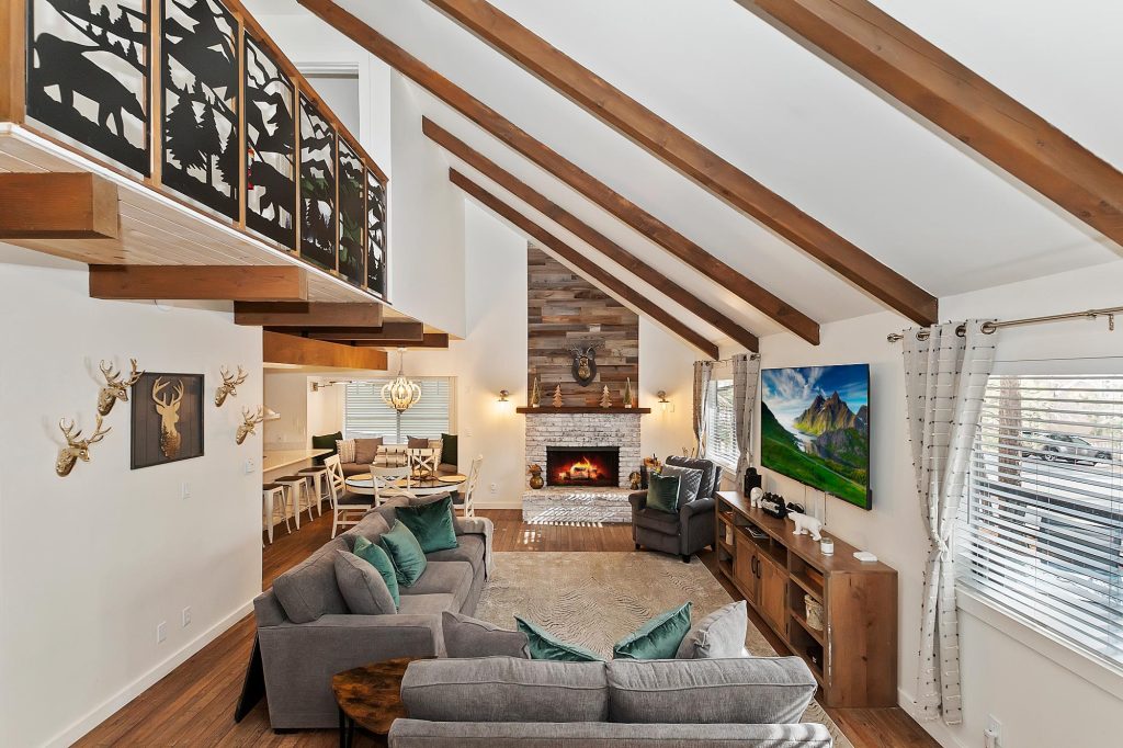 Cozy mountain cabin living room with fireplace, vaulted ceiling, and comfortable seating