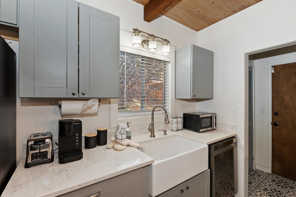 Modern cabin kitchen with farmhouse sink, gray cabinets, and quartz countertops