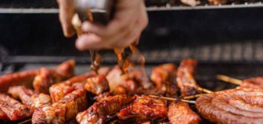 Grilled chicken and meat cooking on a barbecue grill with a chef adding seasoning for a flavorful outdoor meal