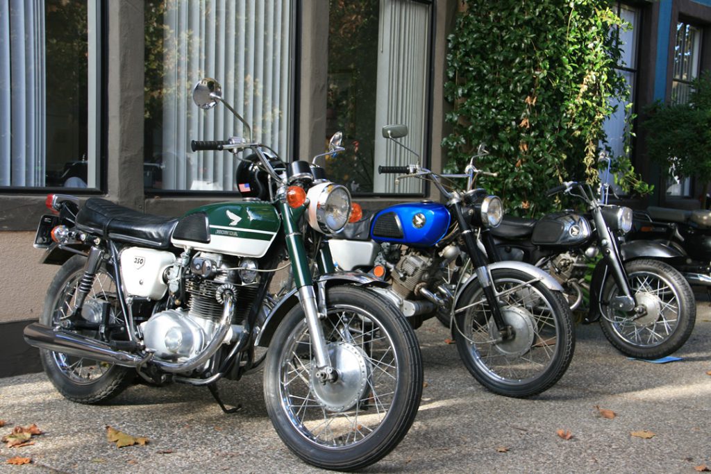 A row of vintage Japanese motorcycles parked on the sidewalk at the Big Bear Motorcycle Show.