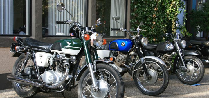 A row of vintage Japanese motorcycles parked on the sidewalk at the Big Bear Motorcycle Show.