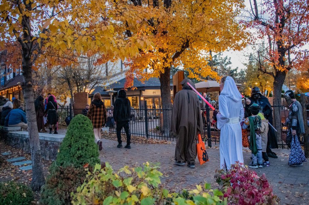 Visitors wearing costumes and enjoying a Halloween event in Big Bear Village during the autumn season