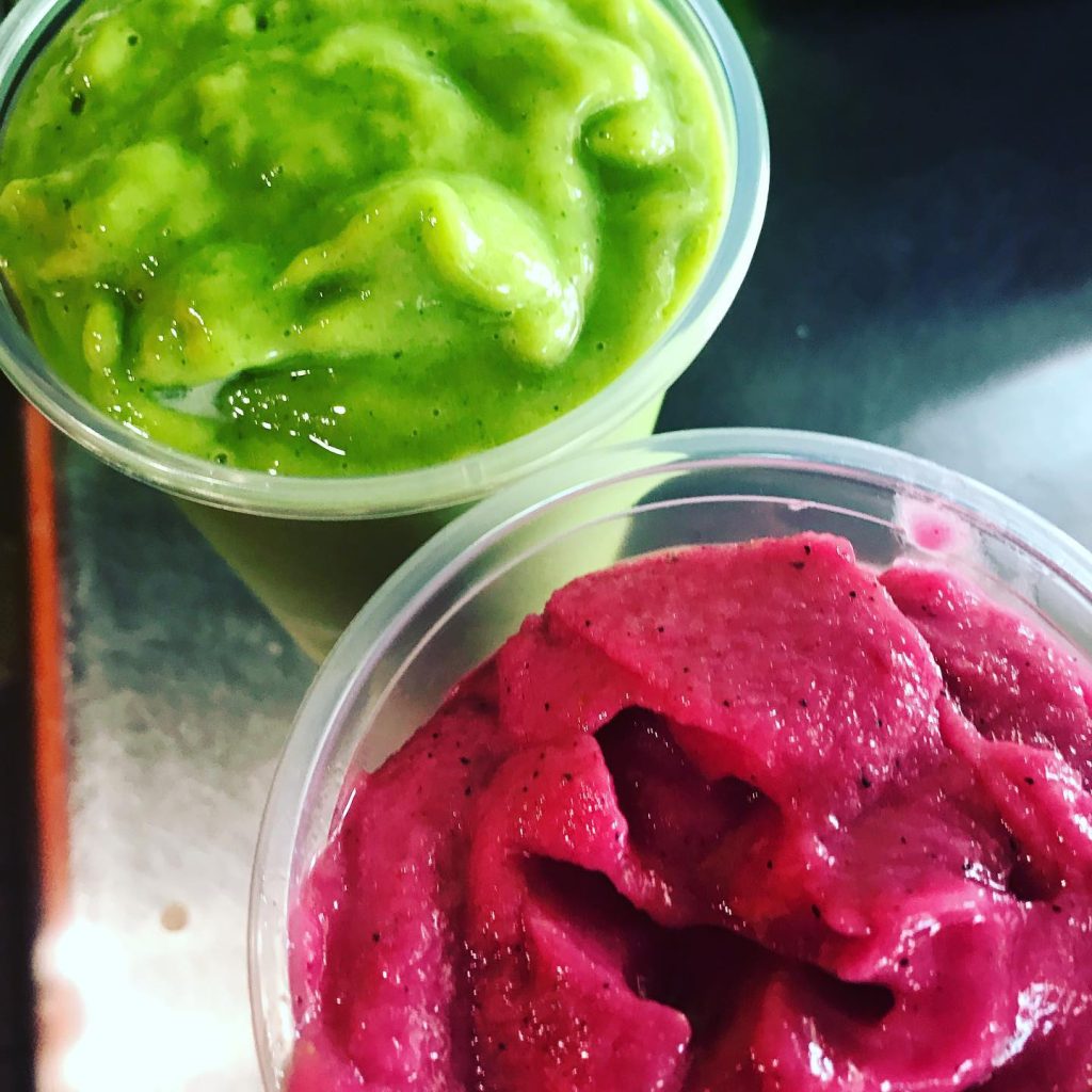 Bright green and pink smoothie bowls from Juice Factory Big Bear featuring fresh fruit flavors and colorful blended ingredients.