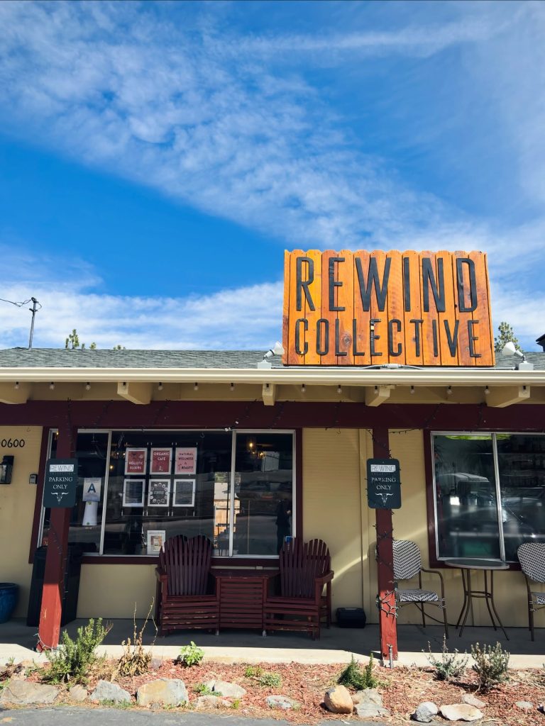 Exterior of Rewind Collective in Big Bear featuring a rustic storefront with wellness, organic café, and community space signage.