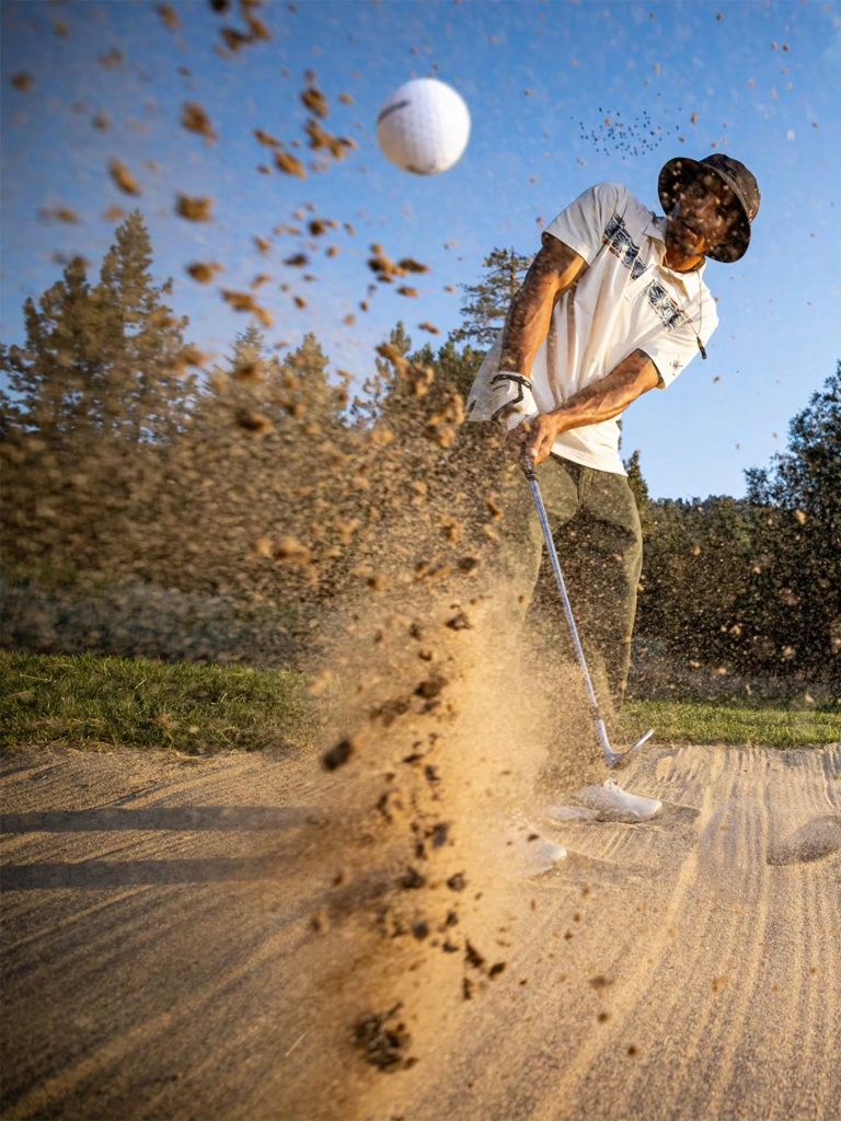 Golfer hitting a bunker shot at Bear Mountain Golf Course in Big Bear Lake.