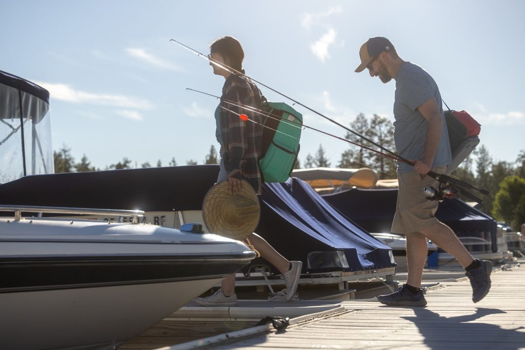 Guests preparing for a fishing trip at the lake dock with boats, fishing gear, and outdoor recreation equipment