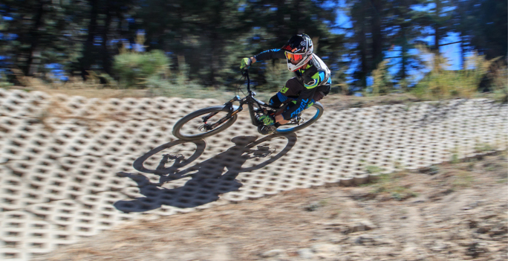 A mountain biker races downhill on a dirt track at Big Bear.