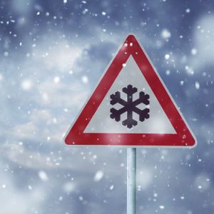 A red and white sign featuring a snowflake, indicating winter conditions at Big Bear Lake.