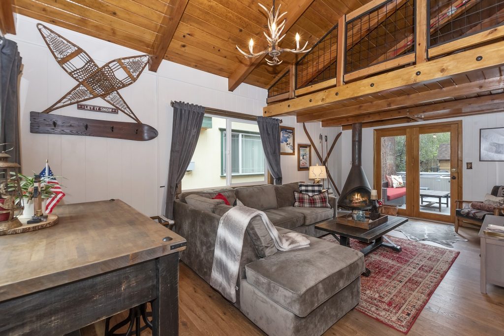 Cozy living room at Sunset Ski Inn featuring a fireplace, mountain-style decor, vaulted wood ceiling, and comfortable seating area